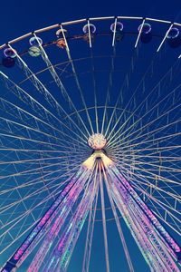 Low angle view of illuminated ferris wheel against sky at night