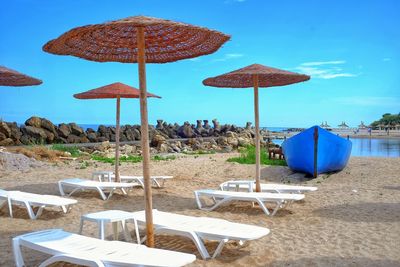 Parasols and chairs on beach against sea