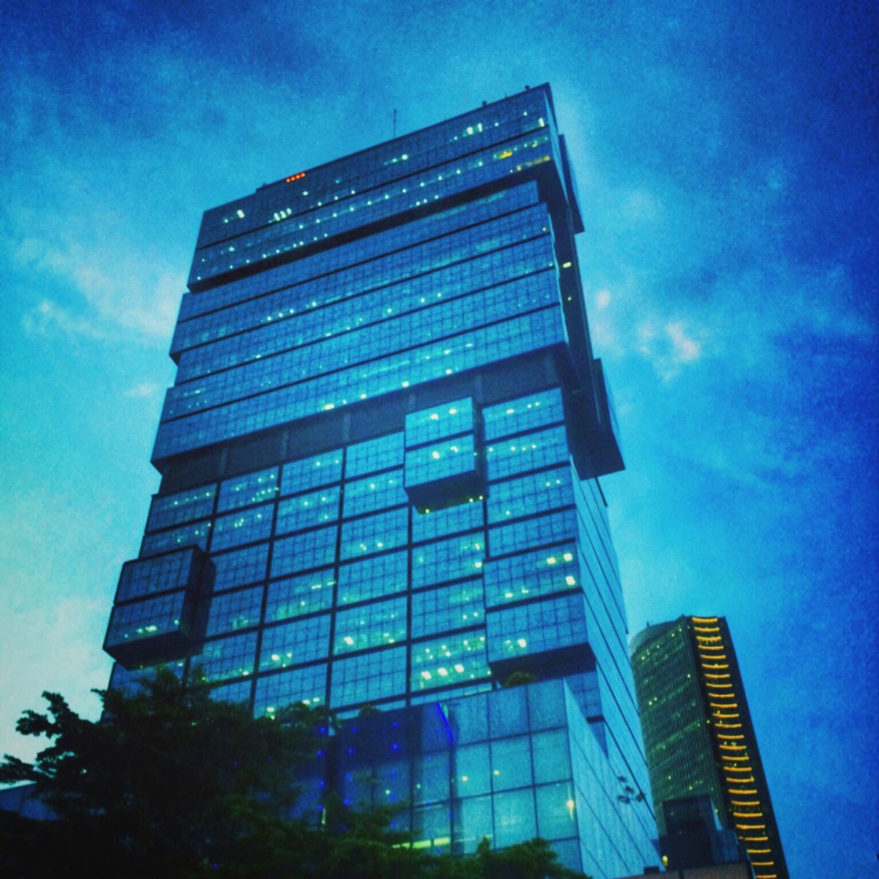 architecture, building exterior, low angle view, built structure, modern, skyscraper, office building, tall - high, city, sky, tower, building, glass - material, reflection, blue, tall, cloud - sky, cloud, no people, outdoors