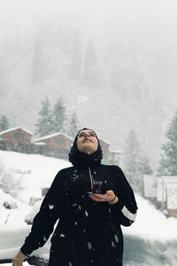 Man standing on snow covered landscape during winter