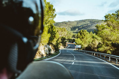 Road amidst trees seen through car windshield