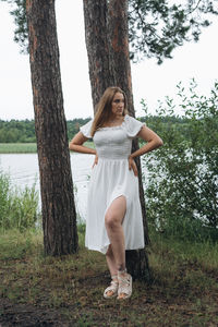 Portrait of young woman standing on field