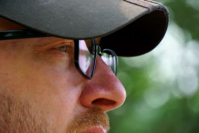 Close-up of man wearing cap and eyeglasses