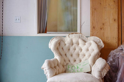 White cat on bed against building