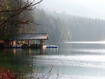 House by lake against trees