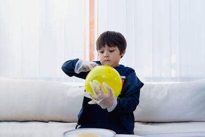 Boy playing with balloon at home