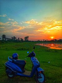 Tractor on field against sky during sunset