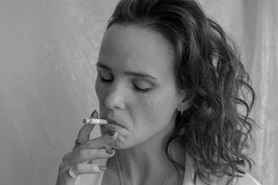 Close-up portrait of woman smoking cigarette