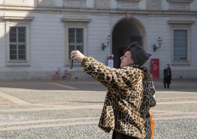 Full length of woman standing on street in city