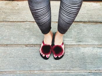 Low section of woman standing on footpath