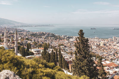 High angle view of townscape by sea against sky