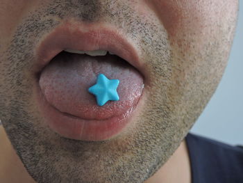 Close-up of man eating blue candies