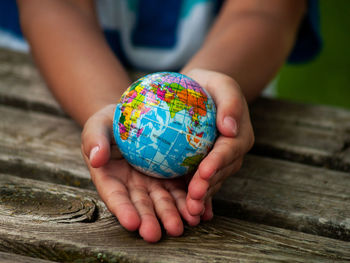 Midsection of boy holding globe