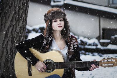 Portrait of a young woman playing guitar