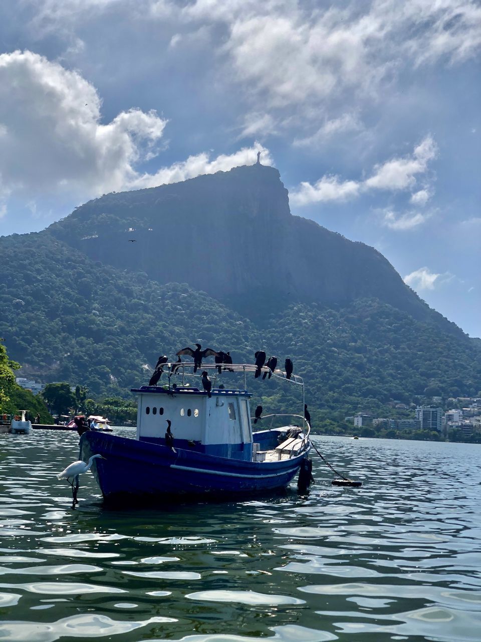 BOAT IN SEA AGAINST MOUNTAIN RANGE