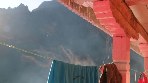 Low angle view of clothes drying on building by mountain