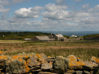 Barn by houses against sky