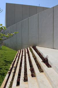 Walkway amidst buildings against sky on sunny day