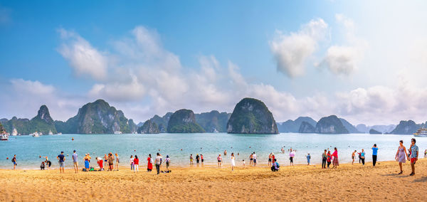 Panoramic view of people on beach against sky