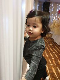 Portrait of cute girl standing at home