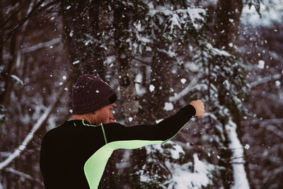 Man punching snowy tree