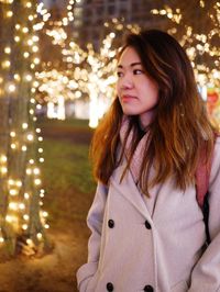 Beautiful young woman looking away while standing in winter