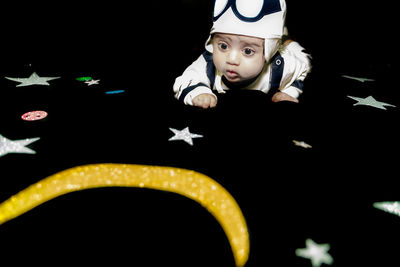 Portrait of cute boy against black background