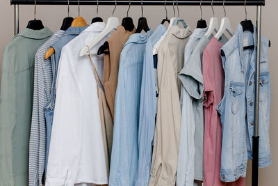 Close-up of a colorful variety of shirts, t-shirts and blouses on hangers inside the closet