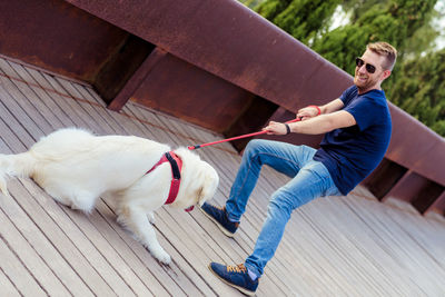 Man walking dog on footbridge