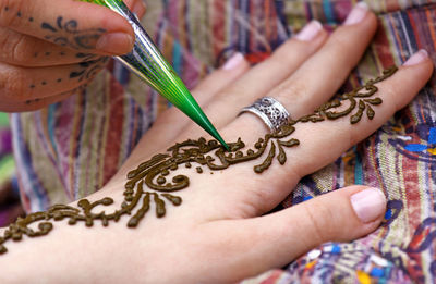 Close-up of hand getting henna tattoo