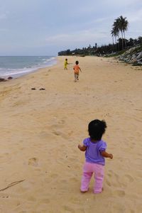 Rear view of boys playing on beach