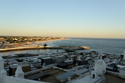 High angle view of town by sea against clear sky