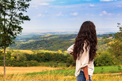 Rear view of woman standing on field