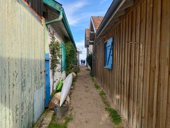 Footpath amidst buildings against sky