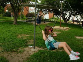 Full length of girl sitting on swing at park