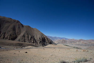 Scenic view of mountains against clear blue sky