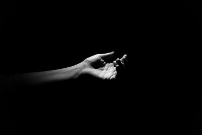 Close-up of man hand over black background