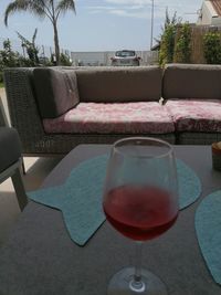 Wine glass on table by swimming pool