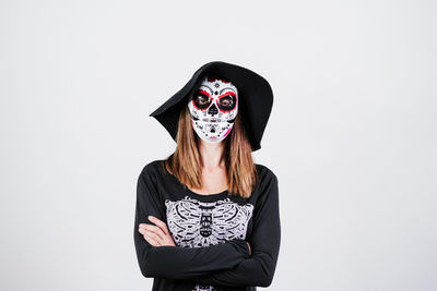 Woman wearing mask standing against white background