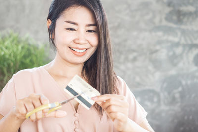 Portrait of a smiling young woman holding camera