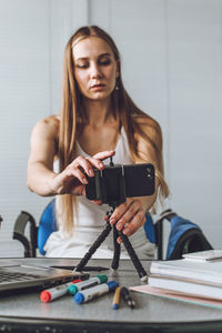 Close-up of beautiful woman blogging at home