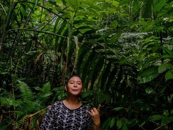 Portrait of woman standing against trees