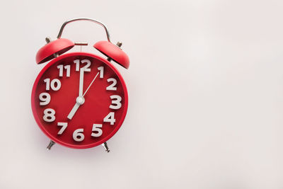 Red clock on wall against white background
