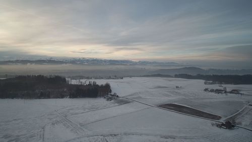 High angle view of snowcapped landscape against sky during winter
