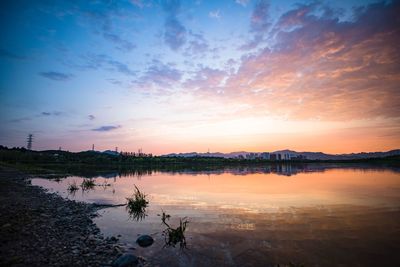 Scenic view of lake against sky at sunset