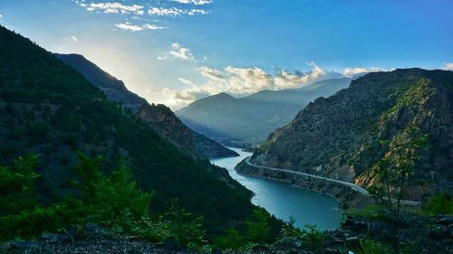 Scenic view of river between mountains against sky