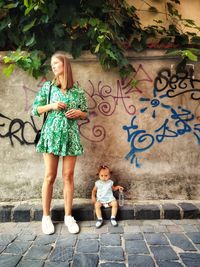 Full length of beautiful blonde woman and her small daughter walking on street