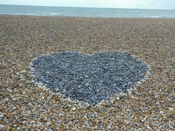 Close-up of pebbles on beach against sky