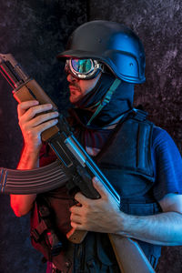 Counterterrorist holding ak-47 against wall