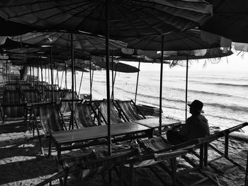 Rear view of man sitting on seat at beach